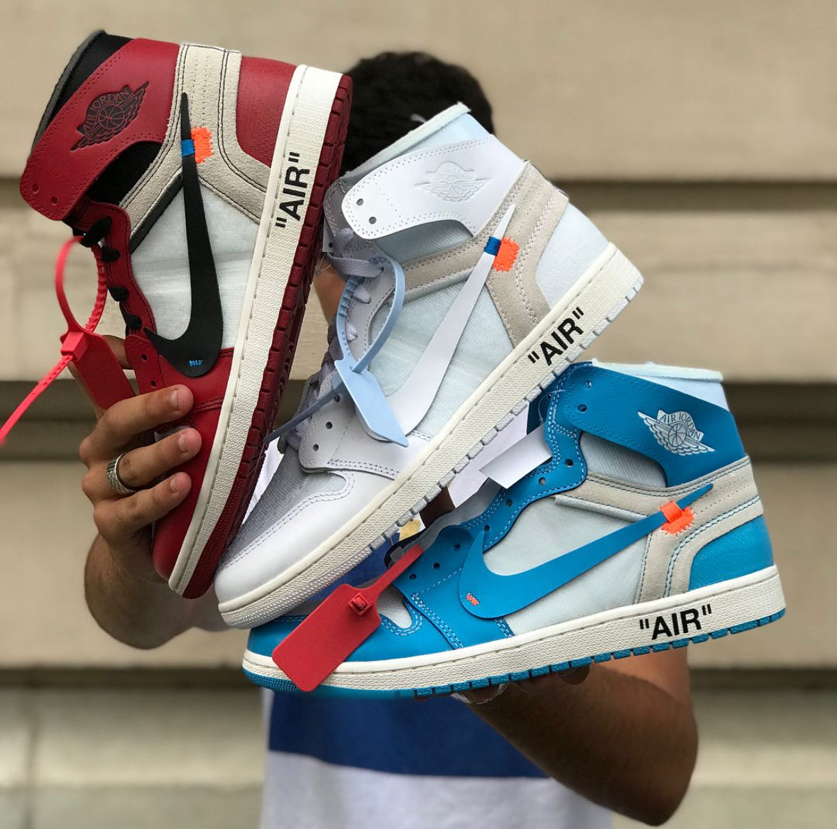 Personne portant trois paires de Jordan 1 High en collaboration avec Virgil Abloh de la marque Off-White, en édition très limitée.